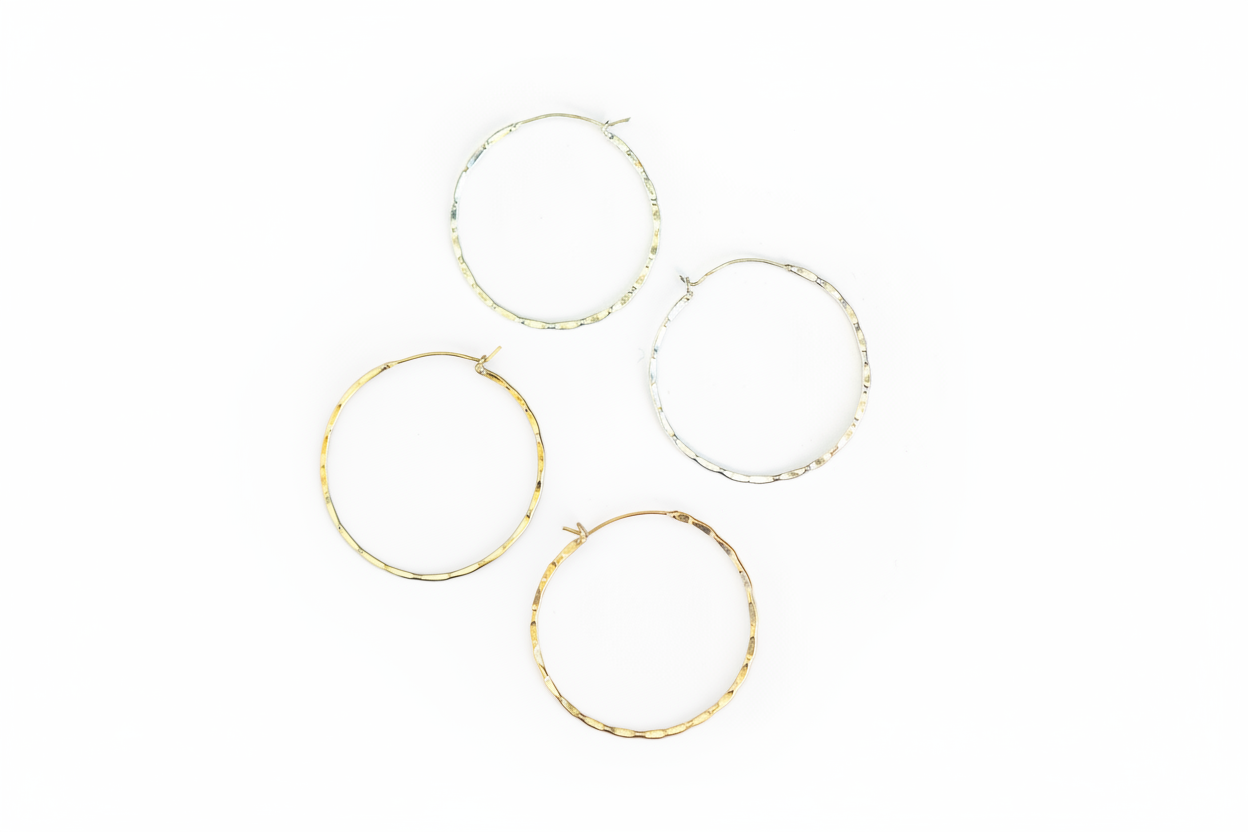 Set of four gold hoop earrings, one set of silver hoops, and one set of gold hoops, on a white background