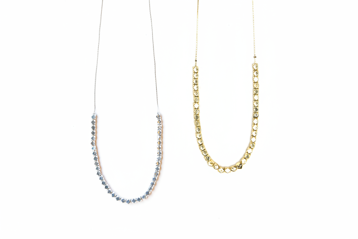 Two necklaces, one with silver beads, one with gold beads.