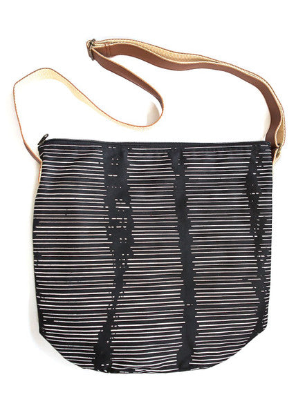 Black and white striped bag with a brown strap on a white background