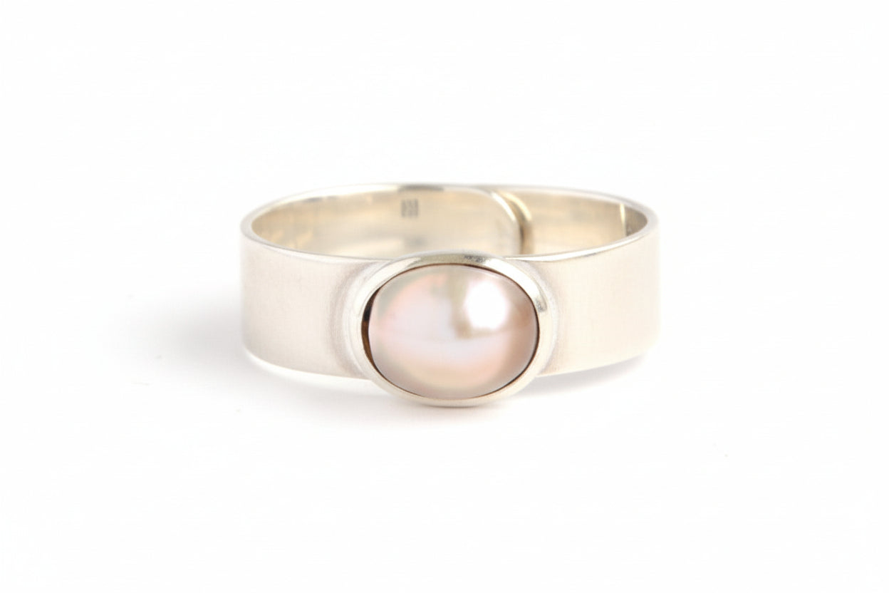 Gold ring with a pearl on a white background
