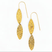 Gold dangle earrings with textured design on a white background
