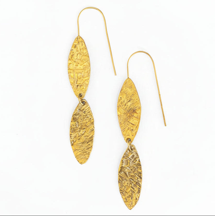 Gold dangle earrings with textured design on a white background